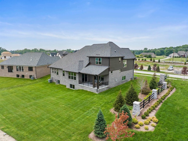 back of house featuring central air condition unit, a lawn, and a patio