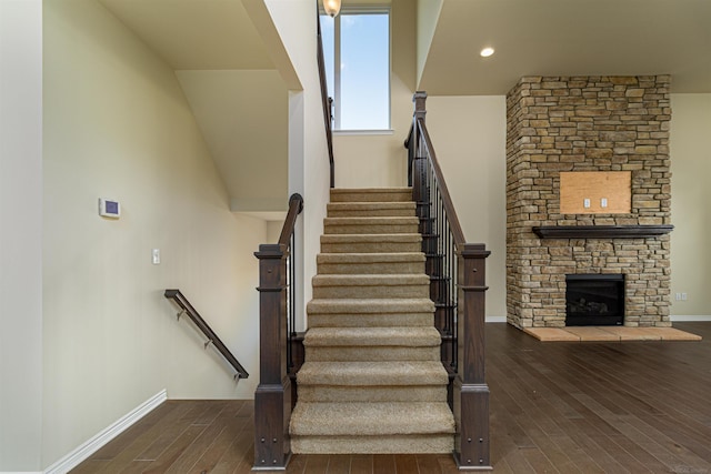 staircase with hardwood / wood-style flooring and a fireplace