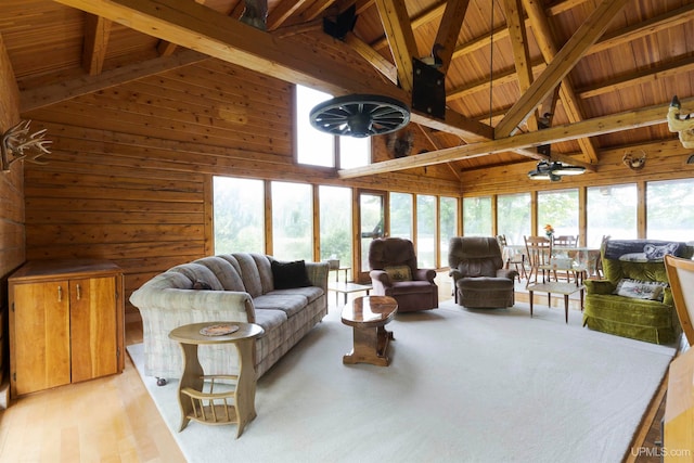 living room with wood walls, beamed ceiling, high vaulted ceiling, and hardwood / wood-style flooring