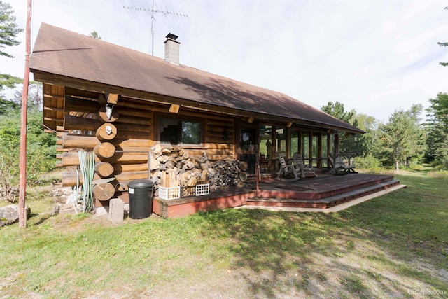 rear view of property featuring a yard and a deck