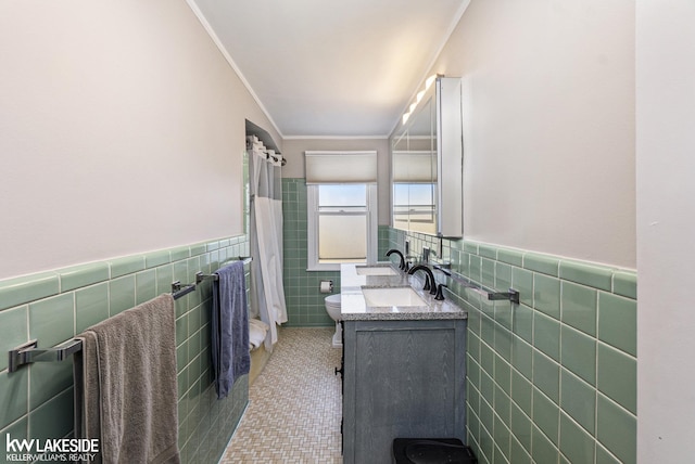 full bath with toilet, ornamental molding, tile walls, and vanity