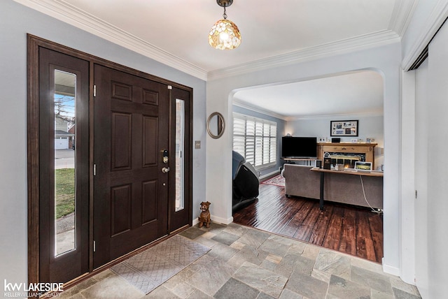 entrance foyer with wood-type flooring, plenty of natural light, and ornamental molding