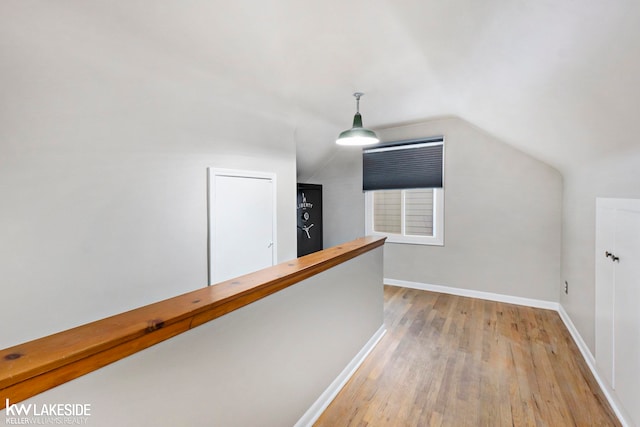 hallway featuring light hardwood / wood-style flooring and vaulted ceiling