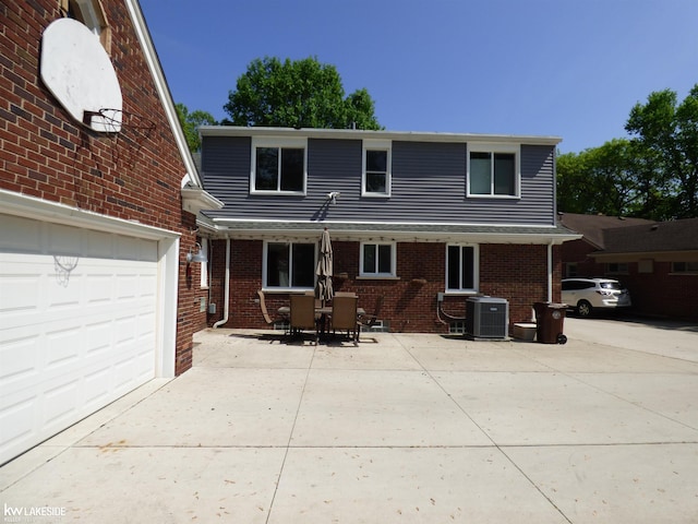 traditional home with concrete driveway, brick siding, and central AC unit