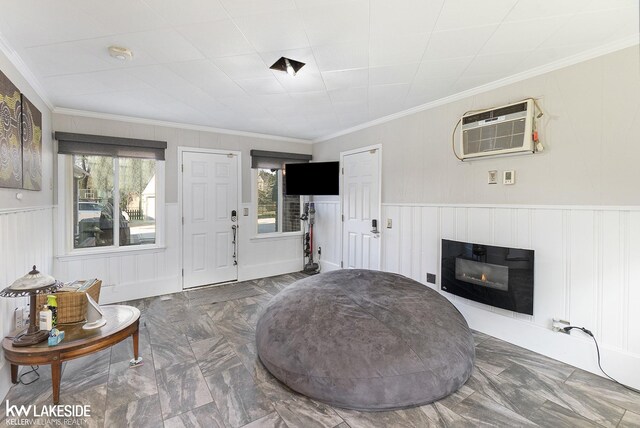 sitting room with ornamental molding and a wall unit AC