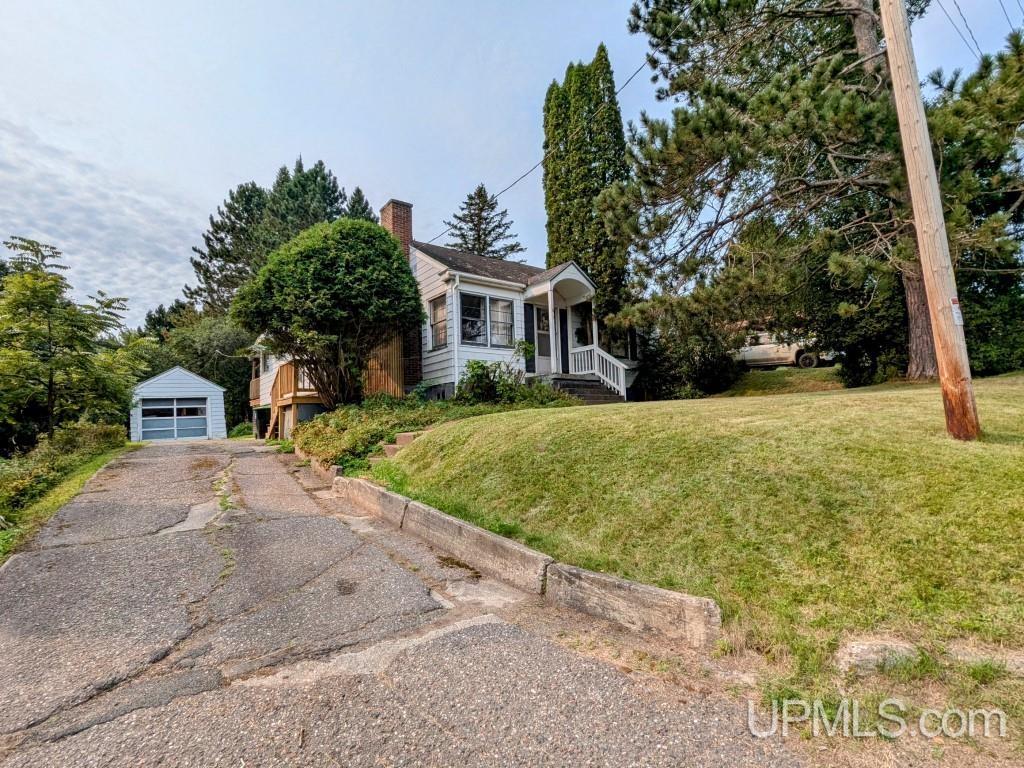 view of front of property with an outdoor structure, a garage, and a front yard