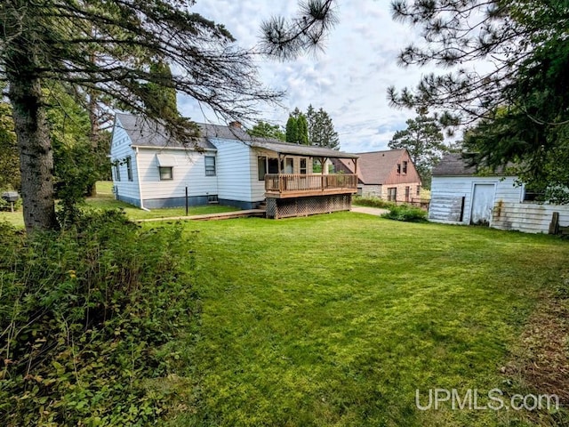 view of yard featuring a storage unit and a wooden deck