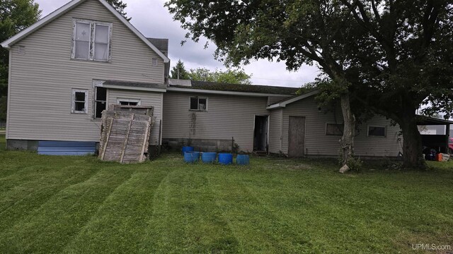 rear view of property featuring a lawn