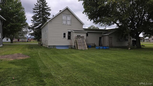 rear view of property featuring a yard