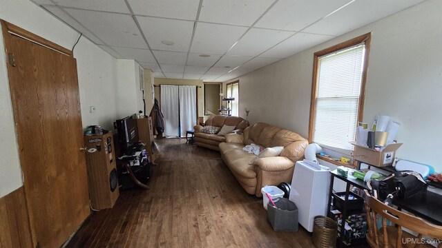 living room with a paneled ceiling and dark hardwood / wood-style flooring