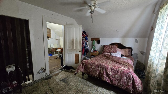 bedroom with lofted ceiling, ceiling fan, and a textured ceiling