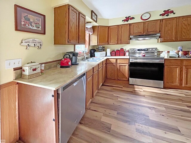 kitchen featuring stainless steel appliances, sink, and light wood-type flooring