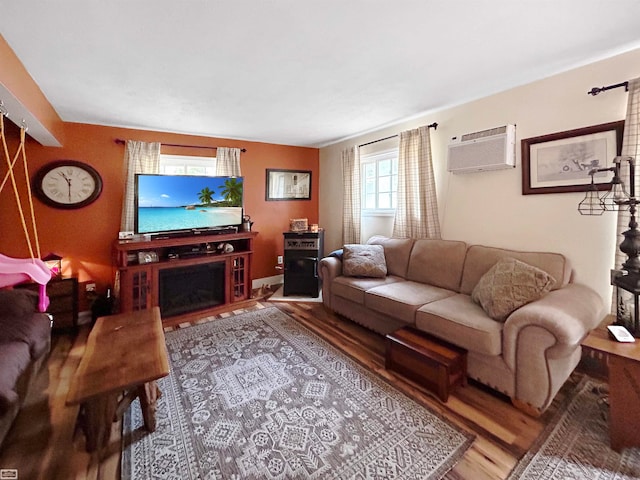 living room featuring wood-type flooring and a wall mounted air conditioner