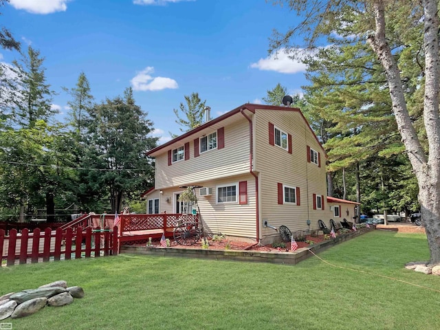 rear view of house featuring a wooden deck and a yard