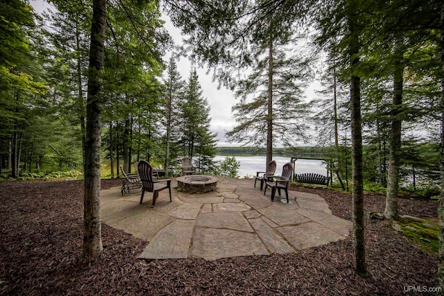 view of patio with a water view and an outdoor fire pit