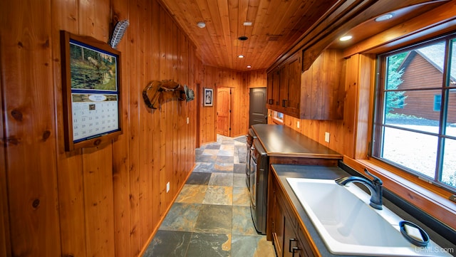 interior space with wood ceiling, sink, and wooden walls