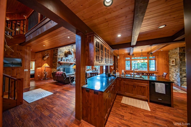 kitchen with wood walls, a fireplace, dark hardwood / wood-style flooring, and kitchen peninsula