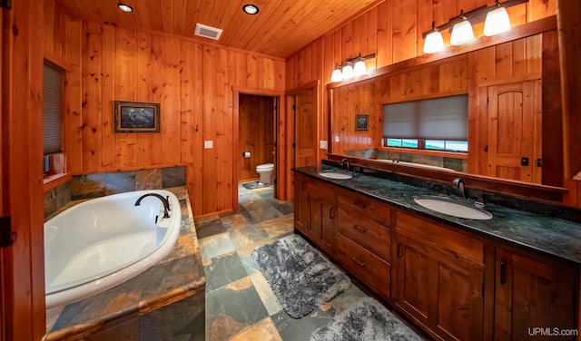 bathroom with wood ceiling, toilet, a bathing tub, wood walls, and vanity