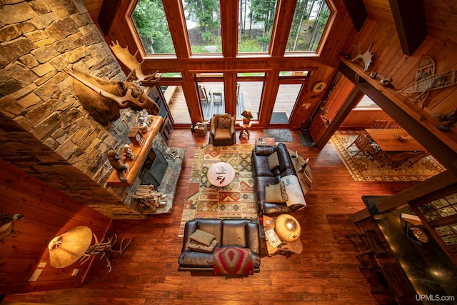 living room with dark wood-type flooring, high vaulted ceiling, a fireplace, and beam ceiling