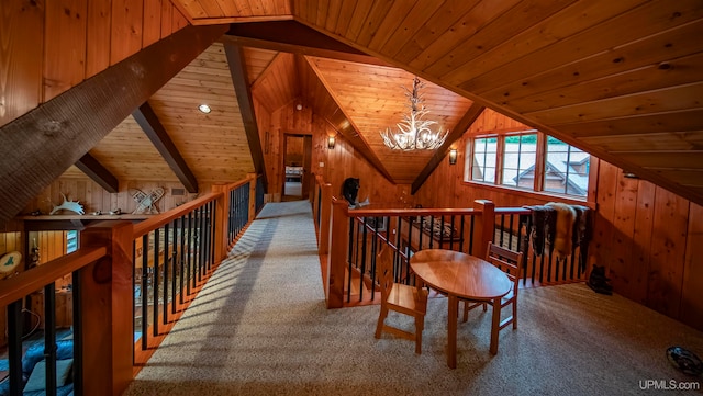 interior space featuring wooden ceiling, carpet, a notable chandelier, and vaulted ceiling