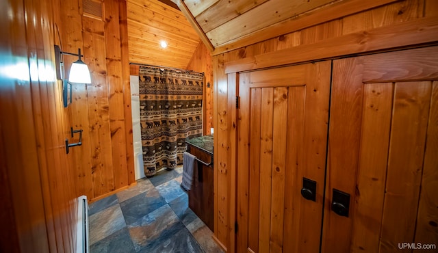 interior space with lofted ceiling, wooden walls, and wood ceiling