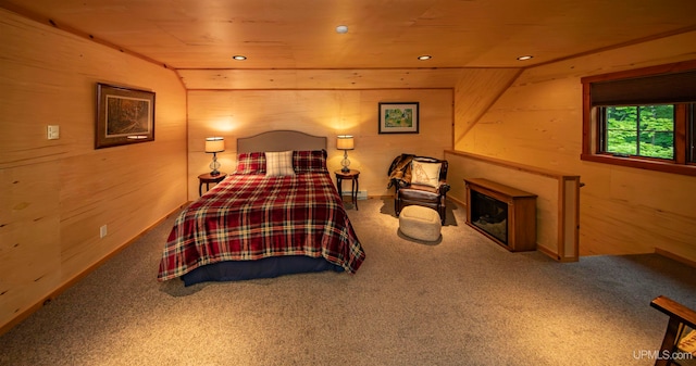 carpeted bedroom featuring vaulted ceiling, wood walls, and wooden ceiling