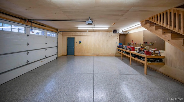 garage with a garage door opener and wood walls