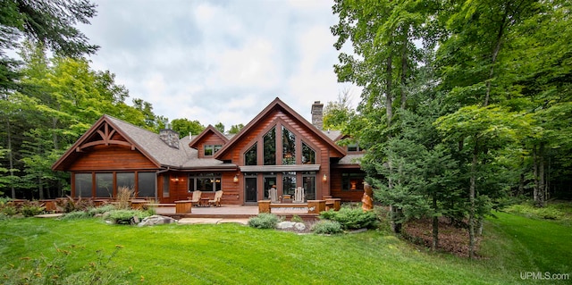 back of property featuring a lawn and a wooden deck