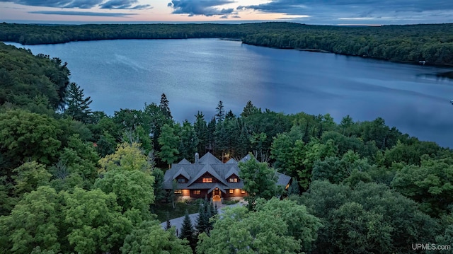 aerial view at dusk featuring a water view