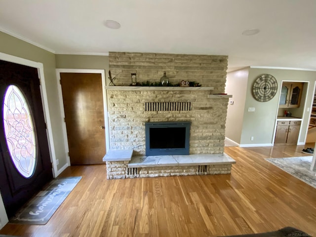 unfurnished living room featuring hardwood / wood-style flooring, crown molding, and a brick fireplace