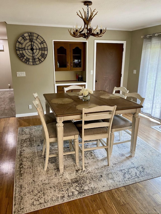 dining room featuring ornamental molding, hardwood / wood-style floors, and a chandelier