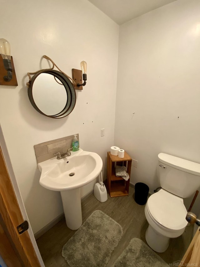 bathroom with wood-type flooring and toilet