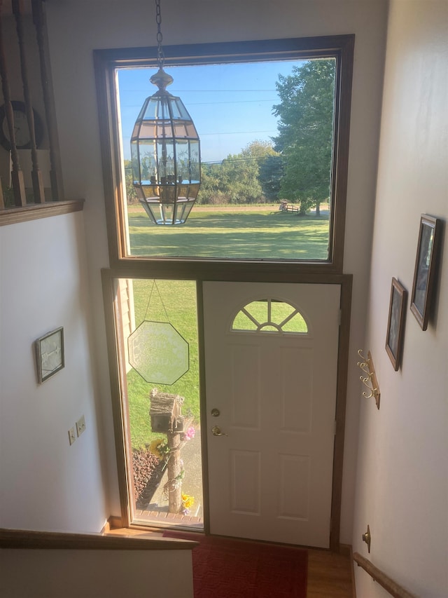 entrance foyer with an inviting chandelier and hardwood / wood-style flooring