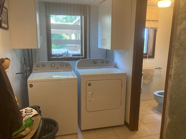 washroom featuring cabinets, separate washer and dryer, and light tile patterned floors