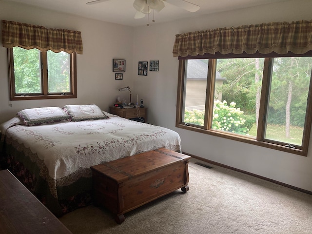 bedroom featuring ceiling fan, carpet floors, and multiple windows