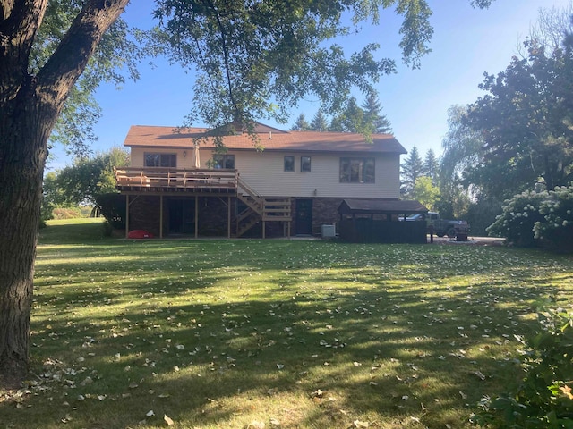 back of house featuring a lawn and a deck