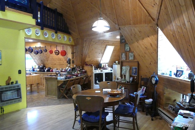 dining space featuring wood walls, wood ceiling, wood finished floors, heating unit, and independent washer and dryer