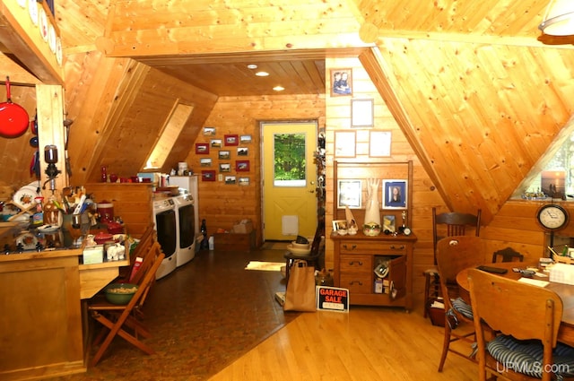 interior space featuring washer and dryer, wood finished floors, wooden walls, wooden ceiling, and lofted ceiling