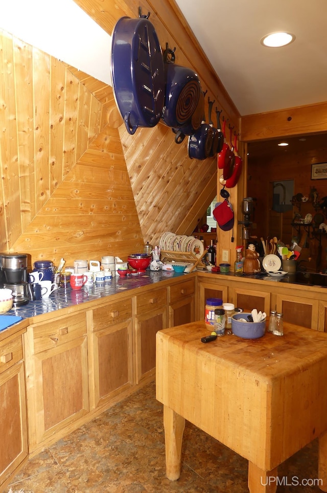 kitchen featuring wooden walls and tile counters