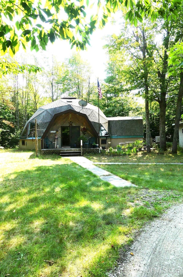 view of front of home featuring a front yard and a shingled roof