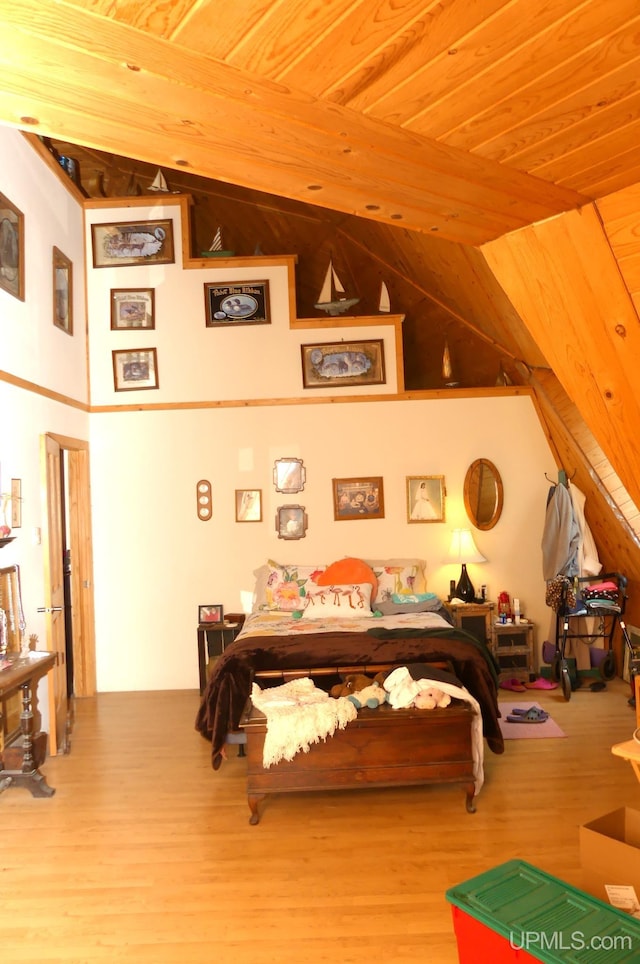 bedroom with wooden ceiling, wood finished floors, and high vaulted ceiling