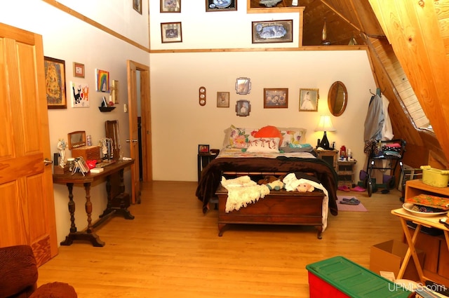 bedroom with a high ceiling and light wood-style floors