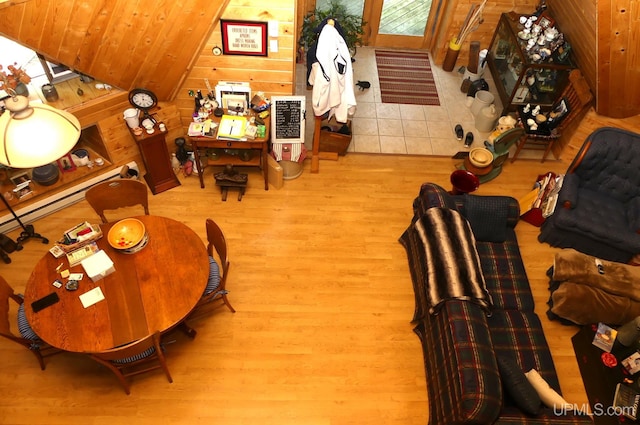 living area with wooden walls, wood finished floors, and vaulted ceiling