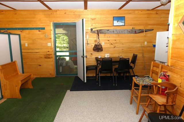 dining space featuring wooden walls and carpet floors