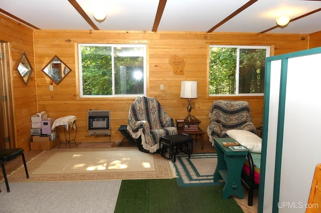 sitting room with heating unit and wood walls