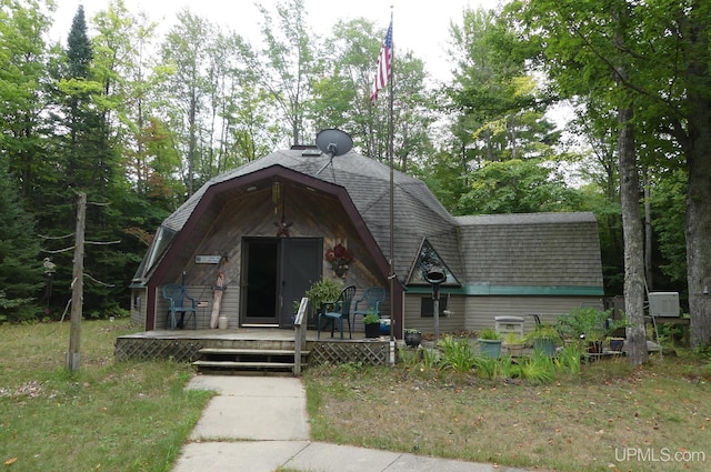 view of front facade with a deck, a gambrel roof, and roof with shingles