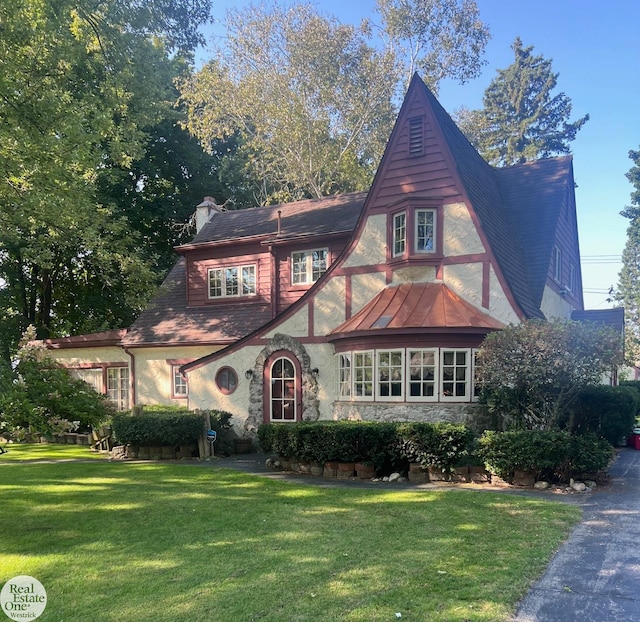 tudor home featuring a front lawn