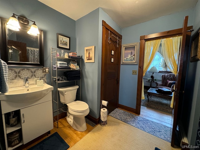 bathroom featuring backsplash, a shower with curtain, vanity, wood-type flooring, and toilet