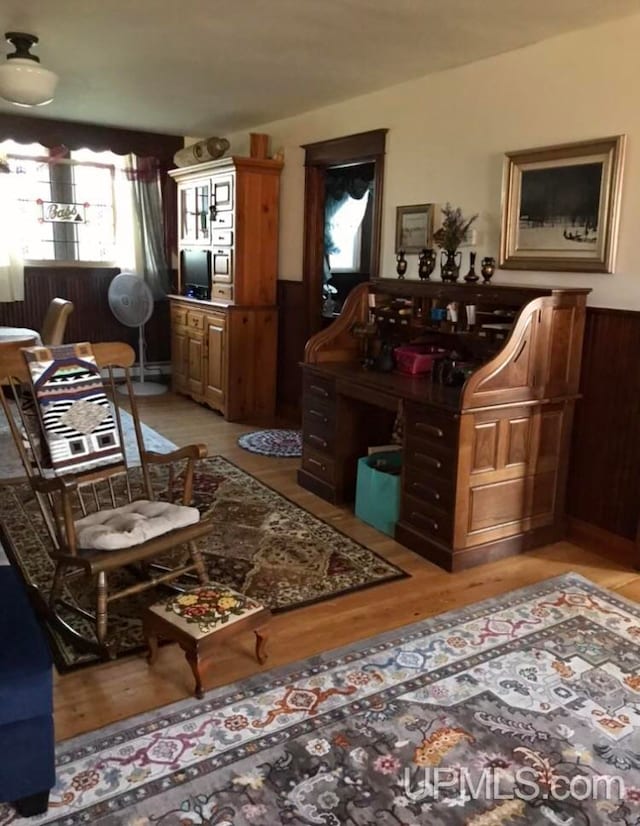 sitting room with wood walls and light hardwood / wood-style flooring