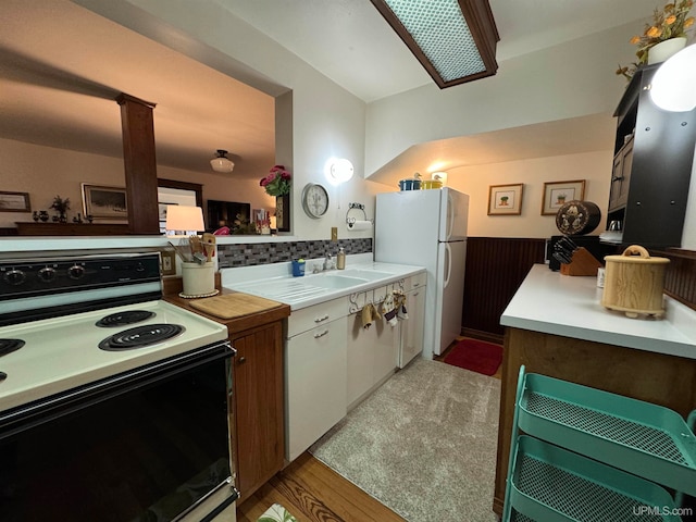 kitchen with light hardwood / wood-style floors, white appliances, and tasteful backsplash